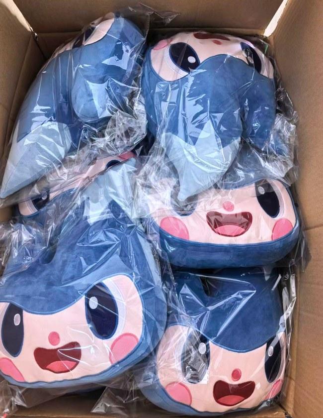 A bulk run of blue shark character plush cushions, bagged in cartons ready for dispatch